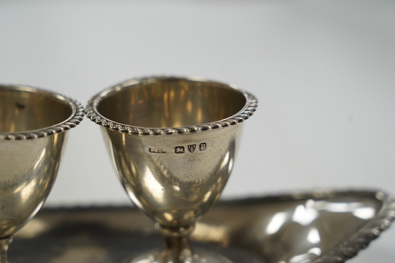 A late Victorian silver egg cruet, with three cups on a navette shaped stand, Chester, 1898, 25.8cm, 10.9oz. Condition - poor to fair